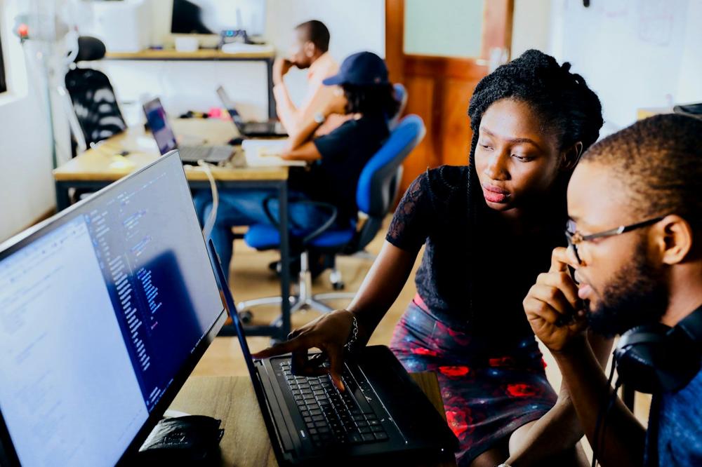 Two colleagues working through a plan on a laptop