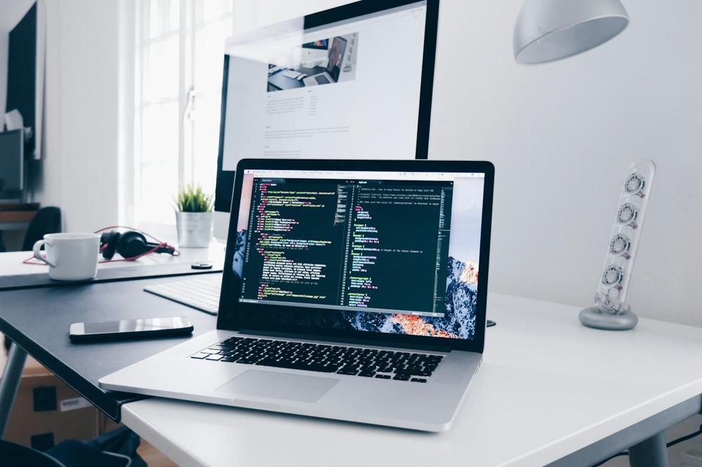 Code on a laptop screen at a bright desk